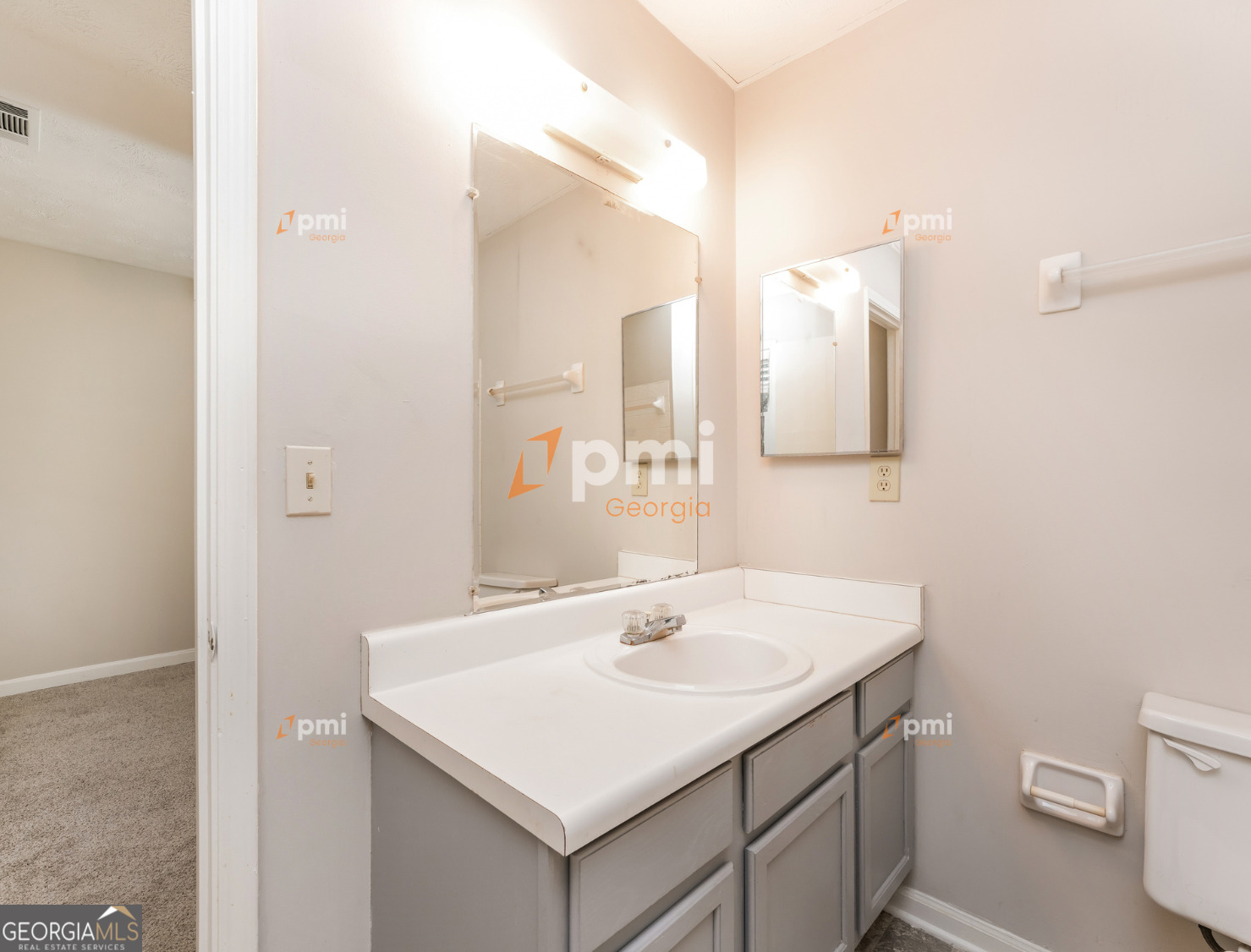667 Rae Drive Southwest Lawrenceville, GA 30044 - Photo 11 of 19 a bathroom with a sink a toilet and a mirror