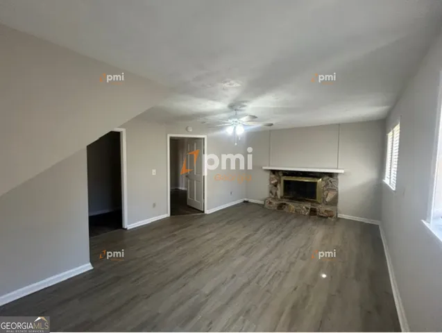 a view of empty room with wooden floor and fireplace