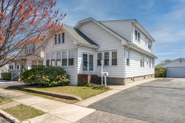 a front view of a house with a yard and potted plants