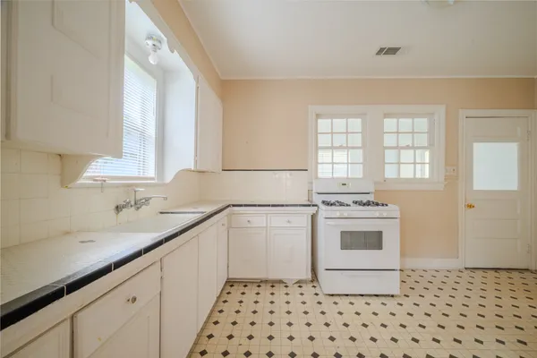 a kitchen with a sink stove and cabinets