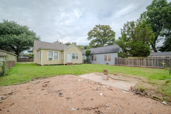 a view of house with backyard and trees