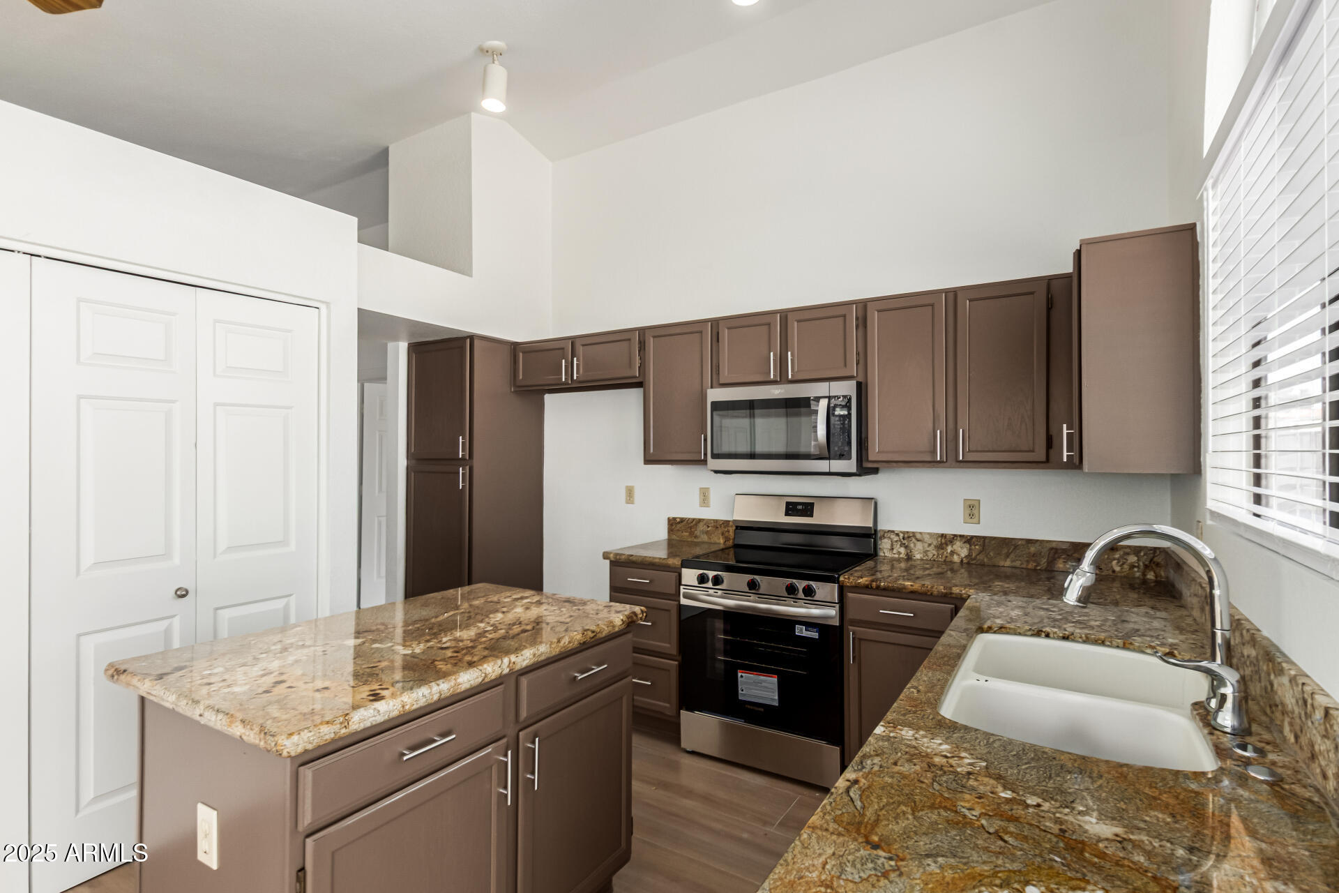 768 South Martinique Drive Gilbert, AZ 85233 - Photo 12 of 27 a kitchen with stainless steel appliances granite countertop a stove top oven a sink dishwasher a dining table and chairs with wooden floor