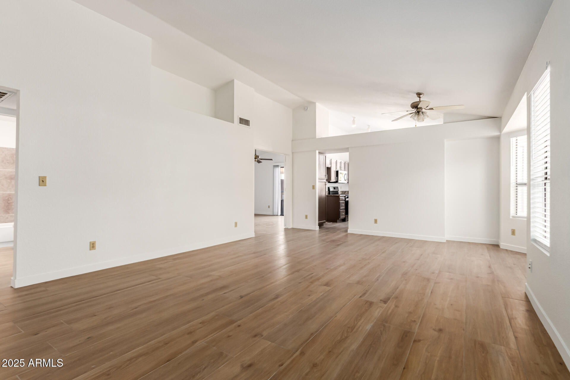 768 South Martinique Drive Gilbert, AZ 85233 - Photo 4 of 27 an empty room with wooden floor and windows