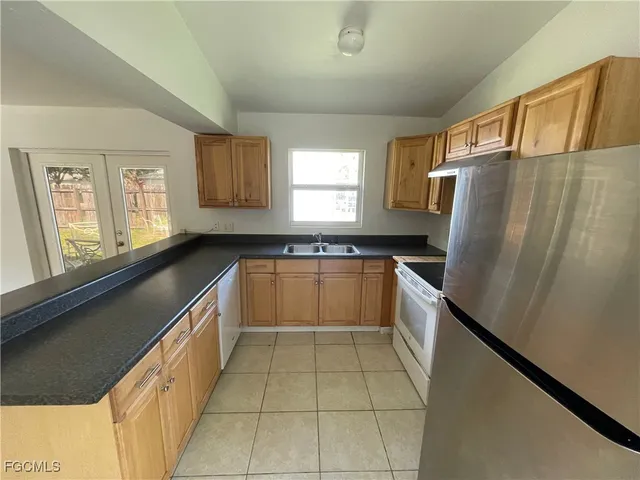 a kitchen with granite countertop a refrigerator and a sink