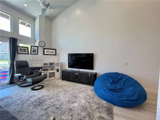 a living room with furniture a flat screen tv and a window