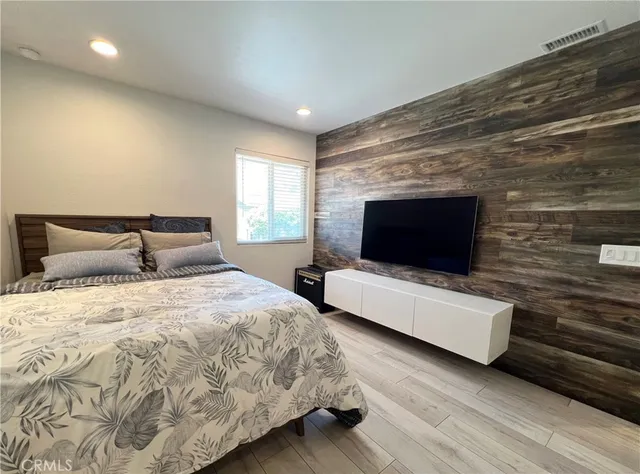 a spacious bedroom with a bed and a flat screen tv