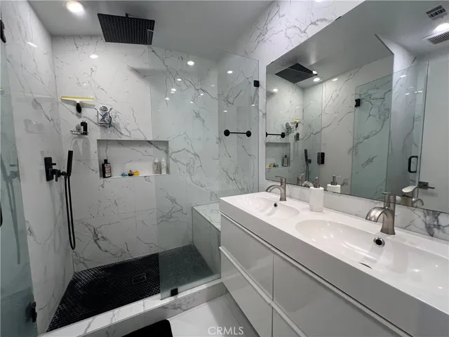a bathroom with a sink a toilet a shower and a mirror