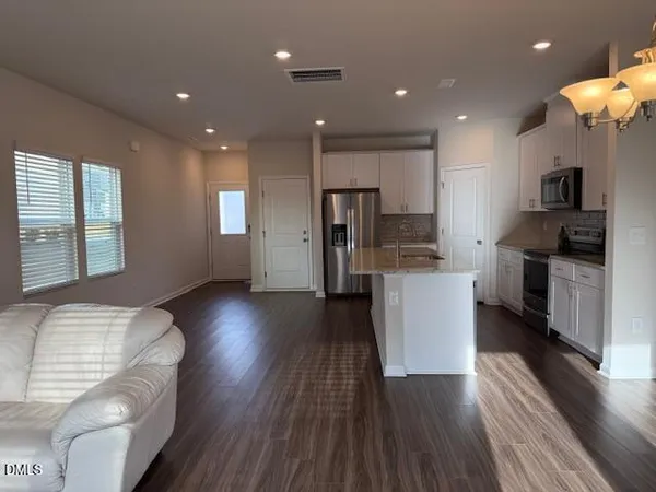 a kitchen with a refrigerator and a stove top oven
