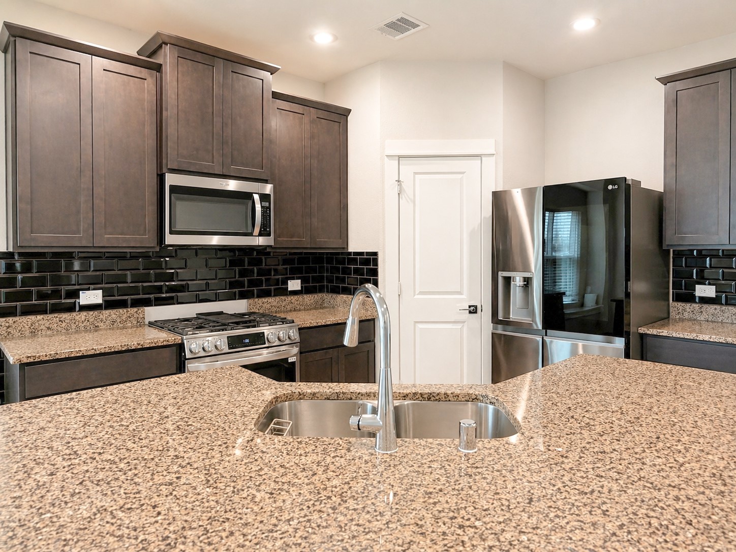 323 Bennett Street Angleton, TX 77515 - Photo 5 of 21 a kitchen with stainless steel appliances kitchen island granite countertop a refrigerator stove and oven