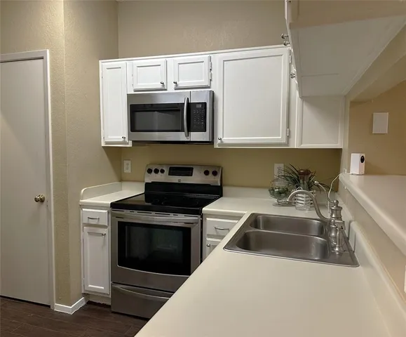 a kitchen with stainless steel appliances a stove a microwave sink and cabinets