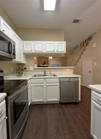 a kitchen with a sink a stove and cabinets