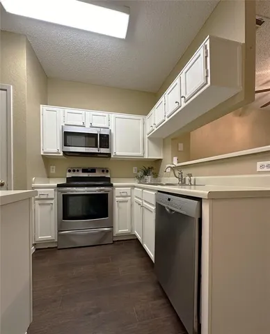a kitchen with sink a microwave and cabinets