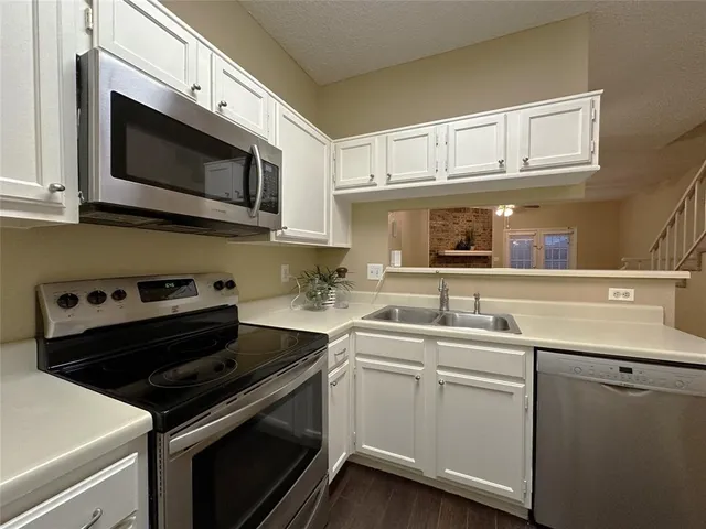 a kitchen with stainless steel appliances a sink dishwasher stove and microwave