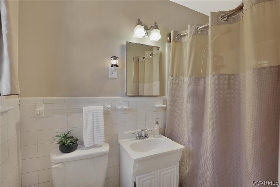 9320 Three Chopt Road Henrico, VA 23229 - Photo 26 of 32 a bathroom with a sink a toilet and shower curtain