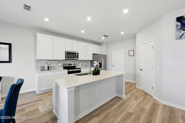 a kitchen with white cabinets and stainless steel appliances