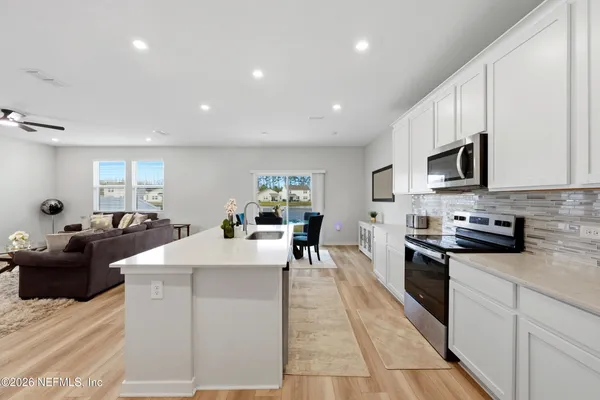 a large white kitchen with stainless steel appliances