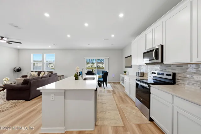 a large white kitchen with stainless steel appliances