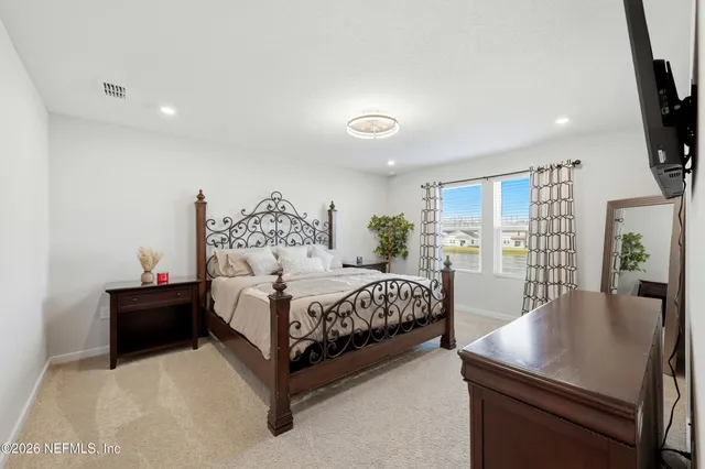 a bed room with a bed window and a flat screen tv