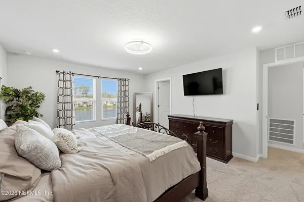 a bedroom with a bed a television and potted plant