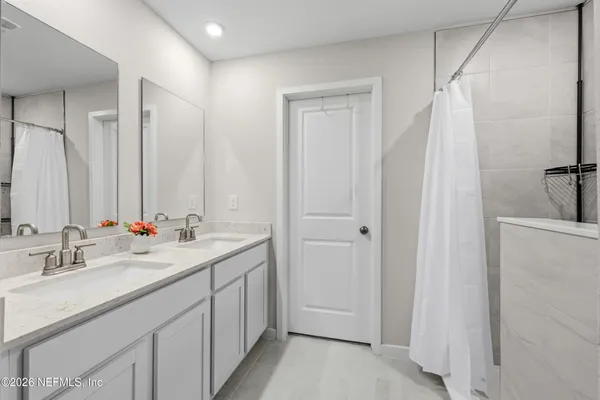 a bathroom with a double vanity sink and a mirror