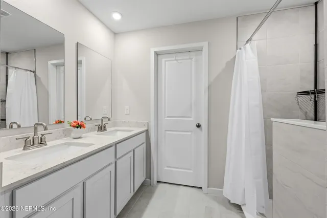a bathroom with a double vanity sink and a mirror