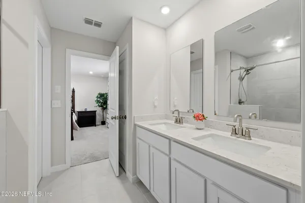 a en suite bathroom with double sink and a mirror