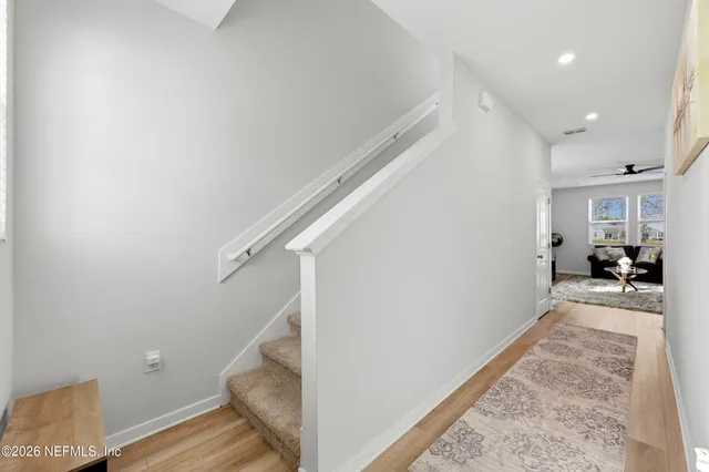 a view of a hallway with wooden floor and staircase