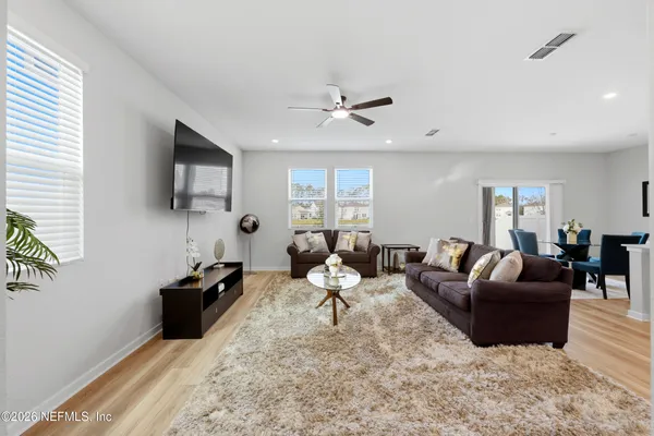 a living room with furniture a flat screen tv and a window