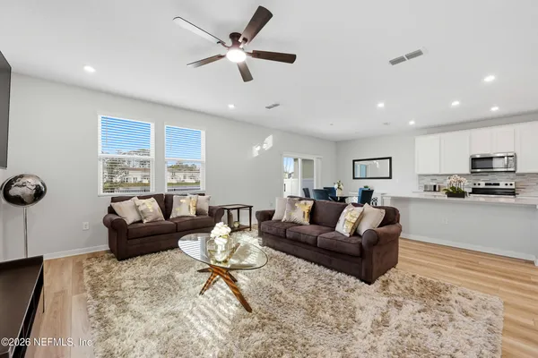 a living room with furniture and kitchen view