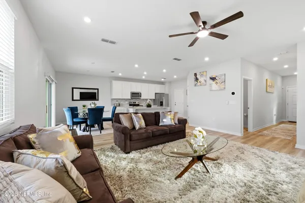 a living room with furniture kitchen view and a window