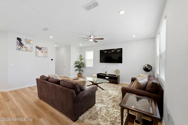 a living room with furniture a flat screen tv and a lamp
