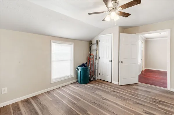 a view of a room with wooden floor and ceiling fan