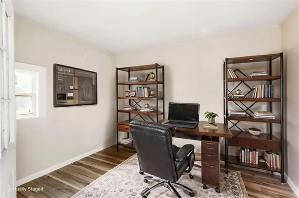 a view of a workspace with furniture and a window