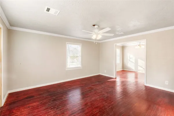 an empty room with wooden floor and window
