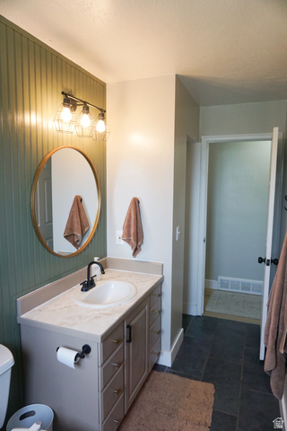 680 Timpie Road Tooele, UT 84074 - Photo 13 of 31 Bathroom featuring a single vanity with an integrated sink, black matte faucet, and ample storage