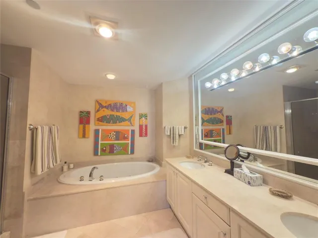 a bathroom with a bathtub a double vanity sink and mirror