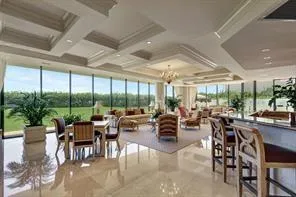 a room with lots of tables a large window and chairs