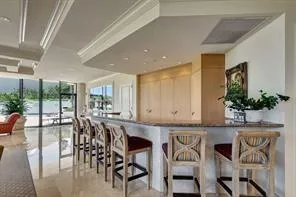a dining hall with stainless steel appliances granite countertop a table and chairs with wooden floor