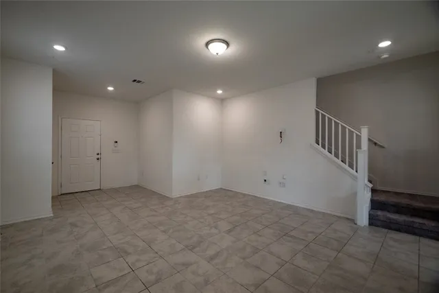 an empty room with chandelier fan