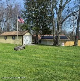a view of house with yard entertaining space and a tree
