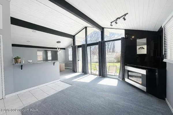 a view of a livingroom with a flat screen tv ceiling fan and window