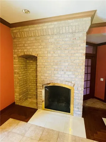 an empty room with windows and fireplace