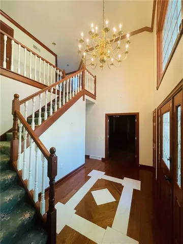 a view of a hallway with front door and wooden floor