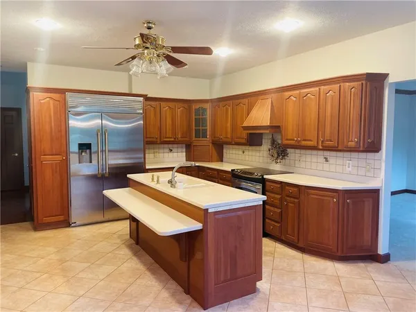 a kitchen with a stove a refrigerator and wooden cabinets