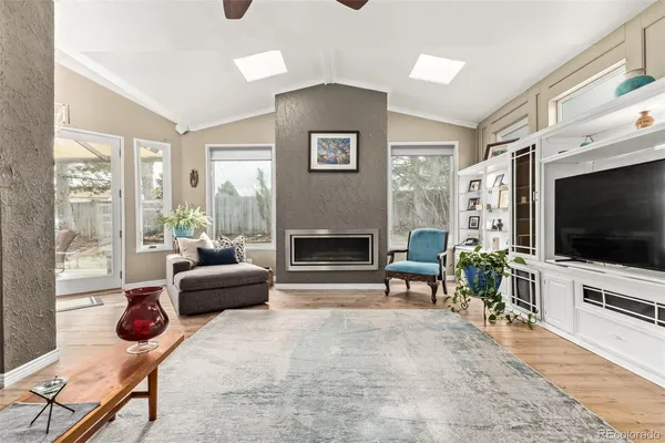 a living room with furniture a flat screen tv and a fireplace