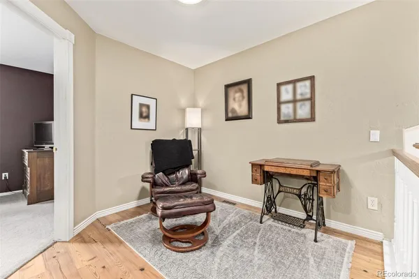 a work room with furniture a piano and wooden floor