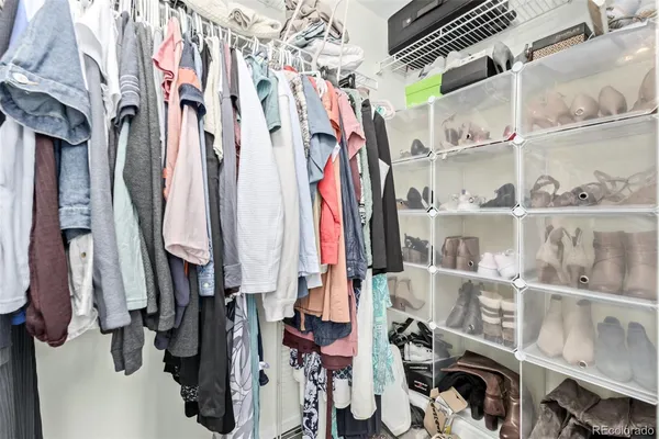a view of walk in closet with clothes and shoes