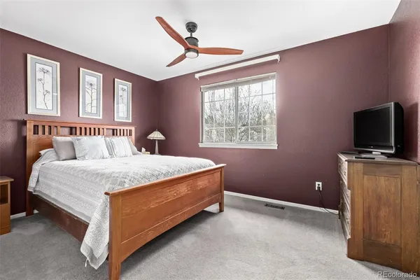 a bedroom with a large bed and a flat tv screen on a dresser