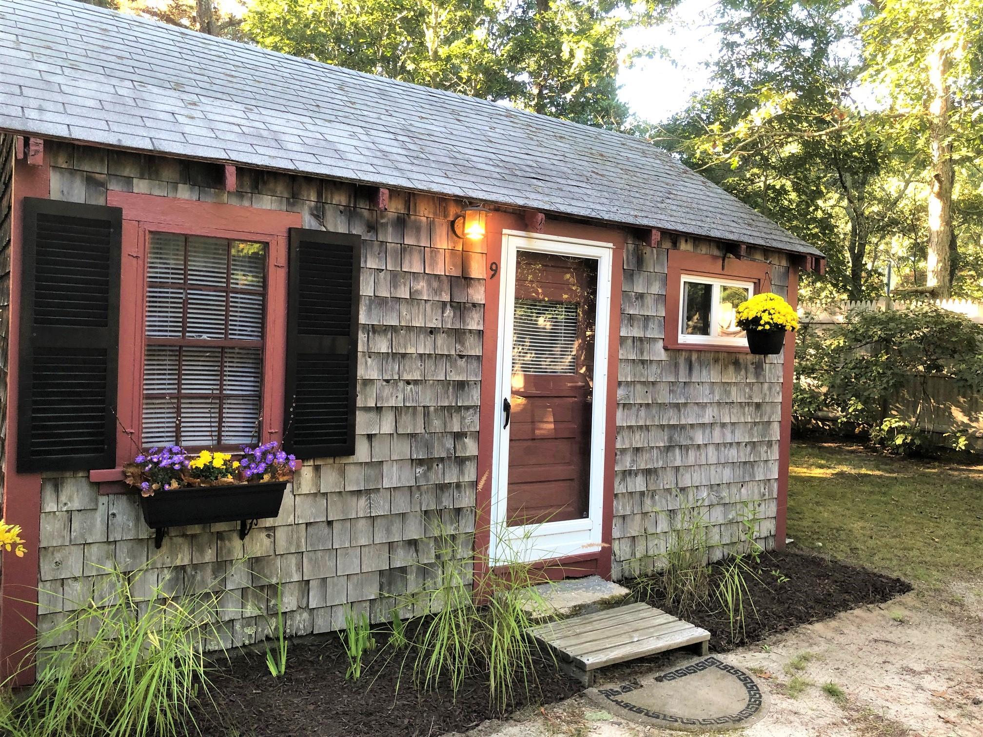 226 Route 6, Unit 9 Truro, MA 02666 - Photo 11 of 12 a front view of a house with a garden