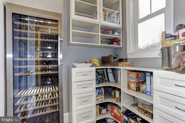 a kitchen with stainless steel appliances granite countertop a stove a refrigerator a kitchen island a dining table and chairs with wooden floor